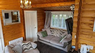 a living room with couches in a log cabin at Snowdonia Log cabin in Trawsfynydd