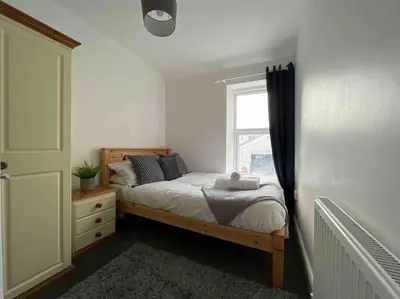 a bedroom with a bed and a window at Modern 2 BR Flat in Town Centre in Aberystwyth