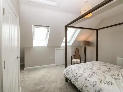 a bedroom with a canopy bed and a window at 1 Crud Y Mor in Barmouth