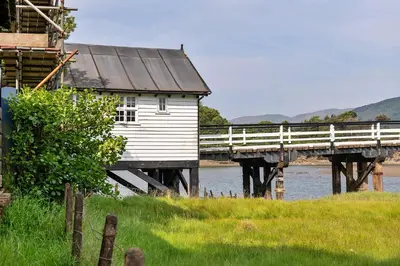 a bridge over a river with a white building at Finest Retreats - Toll Bridge Cottage in Dolgellau