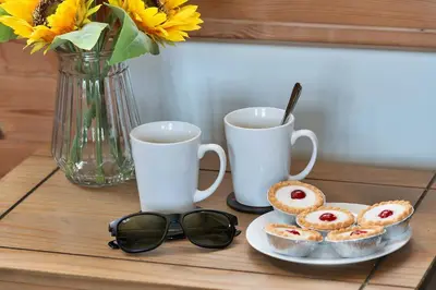 a table with a plate of pastries and two cups of coffee at Finest Retreats - Toll Bridge Cottage in Dolgellau