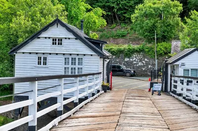 a small white building on a wooden bridge at Finest Retreats - Toll Bridge Cottage in Dolgellau
