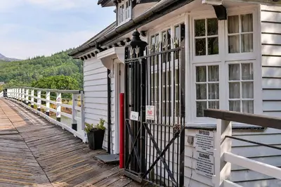 a house with a gate on a wooden deck at Finest Retreats - Toll Bridge Cottage in Dolgellau