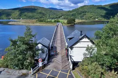 a bridge over a body of water with houses on it at Finest Retreats - Toll Bridge Cottage in Dolgellau
