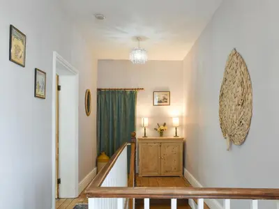a staircase in a home with a green curtain at Upper Broughton Farm Cottage in Snead