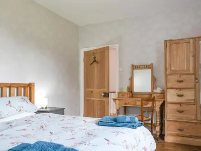 a bedroom with a bed and a desk and a mirror at Upper Broughton Farm Cottage in Snead