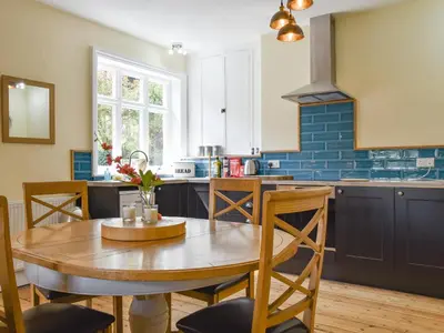 a kitchen with a wooden table and a dining room at Upper Broughton Farm Cottage in Snead