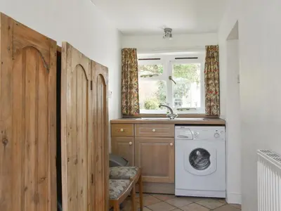 a laundry room with a washing machine and a window at Upper Broughton Farm Cottage in Snead