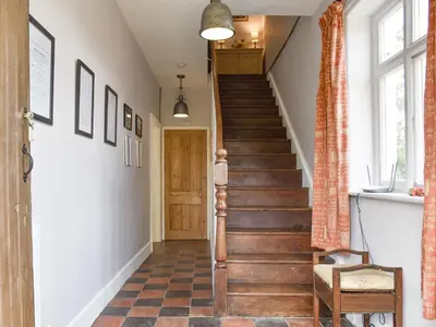 a staircase in a home with a hallway with wood floors at Upper Broughton Farm Cottage in Snead