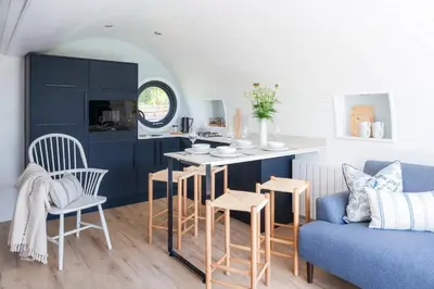 a living room with a couch and a table and chairs at Ceunant in Aberystwyth