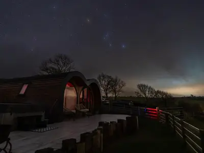 a starry night with a dome tent in a field at Creuddyn in Aberystwyth