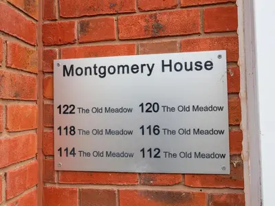 a sign on the side of a brick wall at 122 The Old Meadow in Shrewsbury