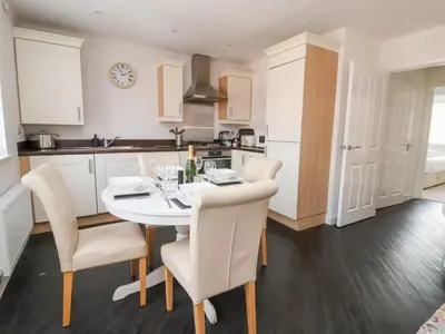 a kitchen with a white table and chairs in a room at 122 The Old Meadow in Shrewsbury
