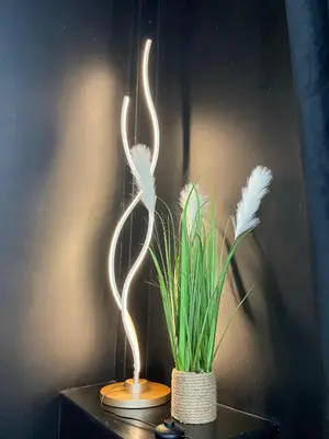 a lighted bird sculpture next to a plant on a table at Flat 1 in Lampeter
