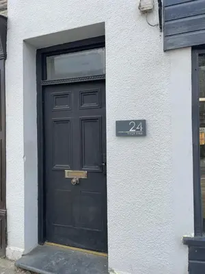 a black door with a sign in front of it at Flat 1 in Lampeter