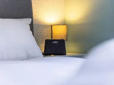 a bed with a laptop on a table with a lamp at The William Morris Lodge in the centre of Ludlow - Pass the Keys in Ludlow