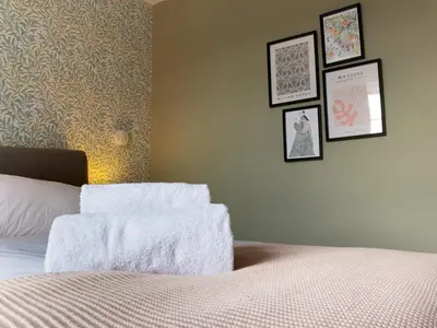 a bedroom with a bed and four pictures on the wall at The William Morris Lodge in the centre of Ludlow - Pass the Keys in Ludlow