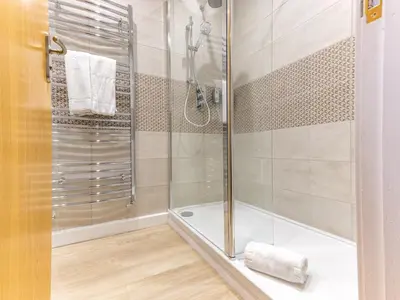 a bathroom with a shower with a glass door at The William Morris Lodge in the centre of Ludlow - Pass the Keys in Ludlow