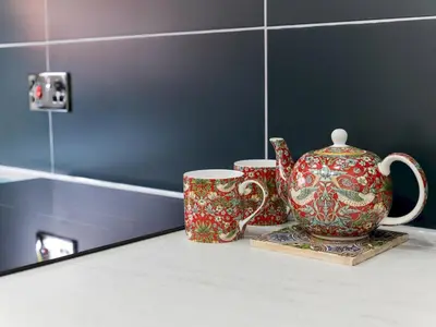 two cups and a tea pot sitting on a counter at The William Morris Lodge in the centre of Ludlow - Pass the Keys in Ludlow