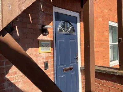 a blue door on the side of a brick building at The William Morris Lodge in the centre of Ludlow - Pass the Keys in Ludlow