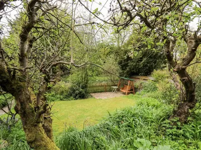a park with a bench in the middle of a garden at Myrtle Villa in Knighton