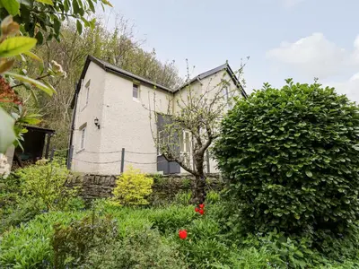 an old house in the middle of a garden at Myrtle Villa in Knighton