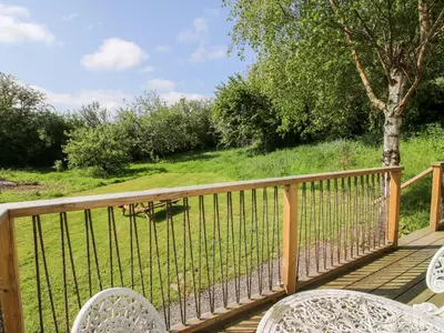 a wooden deck with two chairs and a table at Mucklewick Hollow in Shrewsbury