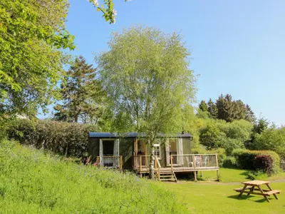a cabin in the middle of a field with a picnic table at Mucklewick Hollow in Shrewsbury