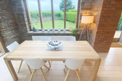 a wooden table and chairs in a room with a window at Ty Hobi Bach - at the foot of the Black Mountains in Brecon
