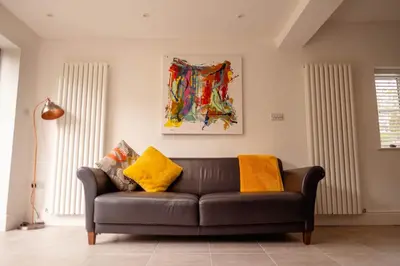 a leather couch in a living room with yellow pillows at Rose Hill in Shrewsbury