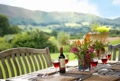 a table with a bottle of wine and wine glasses at The Oaks in All Stretton