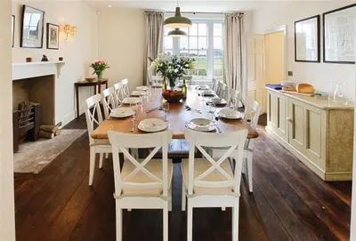 a dining room with a long table and white chairs at Upper Mowley in Kington