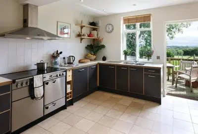 a kitchen with black and white appliances and a patio at Upper Mowley in Kington
