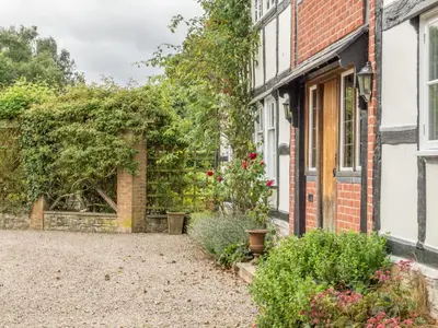 a garden in front of a brick house at Bearwood House & Cottage in Pembridge