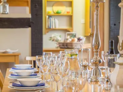 a table with glasses and plates on it with a table at Bearwood House in Pembridge