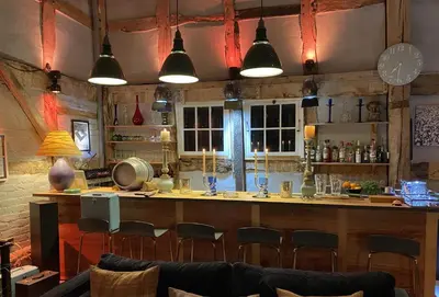 a bar in a restaurant with chairs and lights at Bearwood Cottage in Pembridge