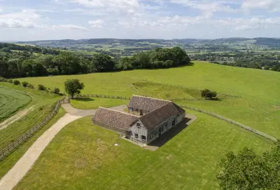 an aerial view of an old house in a field at Wassell Barn in Craven Arms