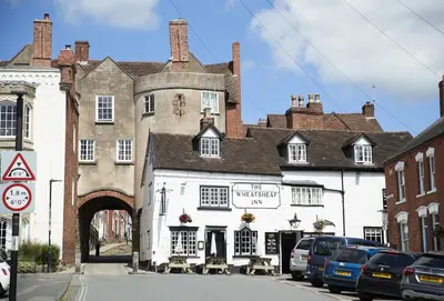 an old building on a street with cars parked outside at Wassell Barn in Craven Arms