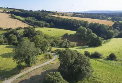 an aerial view of a road in a field with trees at Pear Tree Cottage Shropshire in Orleton