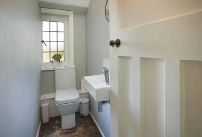a bathroom with a toilet and a sink and a window at Green Gables in Eardisley