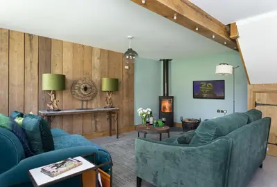 a living room with blue couches and a fireplace at The Timber Barn in Downton