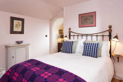 a bedroom with a large bed with a purple blanket at Stone House in Leominster