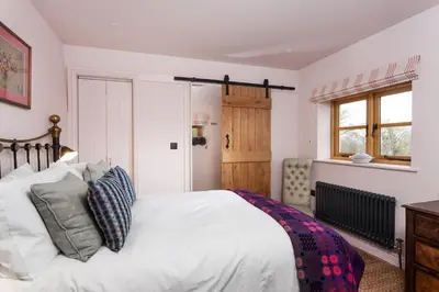 a bedroom with a white bed and a window at Stone House in Leominster