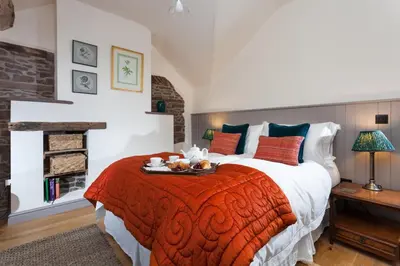 a bedroom with a large bed with a red blanket at Stone House in Leominster