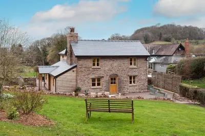 a house with a bench in front of it at Stone House in Leominster