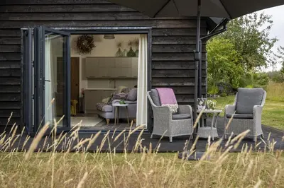 a screened in porch of a house with chairs and an umbrella at Broomers Barn in Lane to Richards Castle