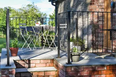 a wrought iron fence with potted plants on a patio at The Groom's Flat in Leominster