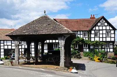 an old black and white building with a gazebo at The Groom's Flat in Leominster