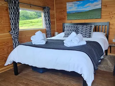 a bedroom with a bed with towels on it at Wye Valley Cabin in Upper Welson