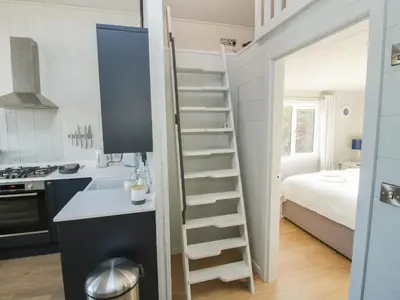 a small kitchen with a ladder in a tiny house at Little Shelve Barn in Shrewsbury